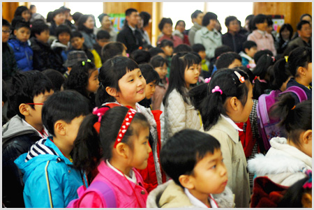 학교안 교실에 옹기종기 모여있는 학생들 사진